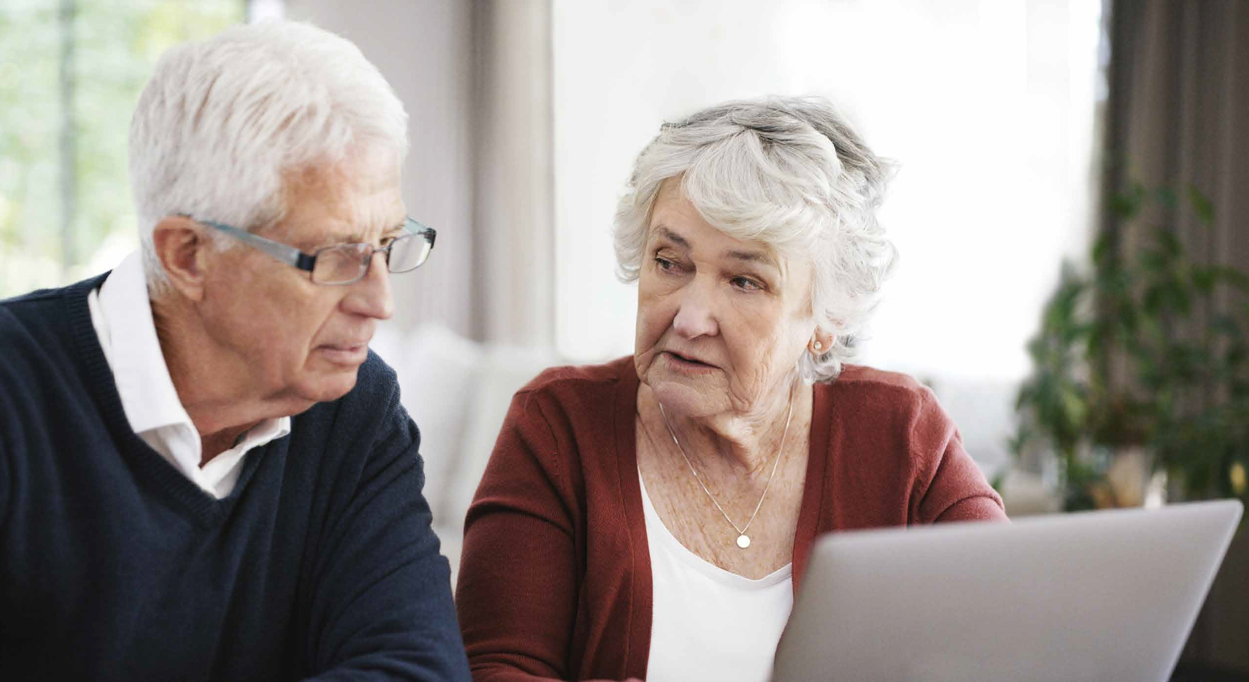 Ældre ægtepar sidder ved en computer og læser om kronisk nyresygdom.